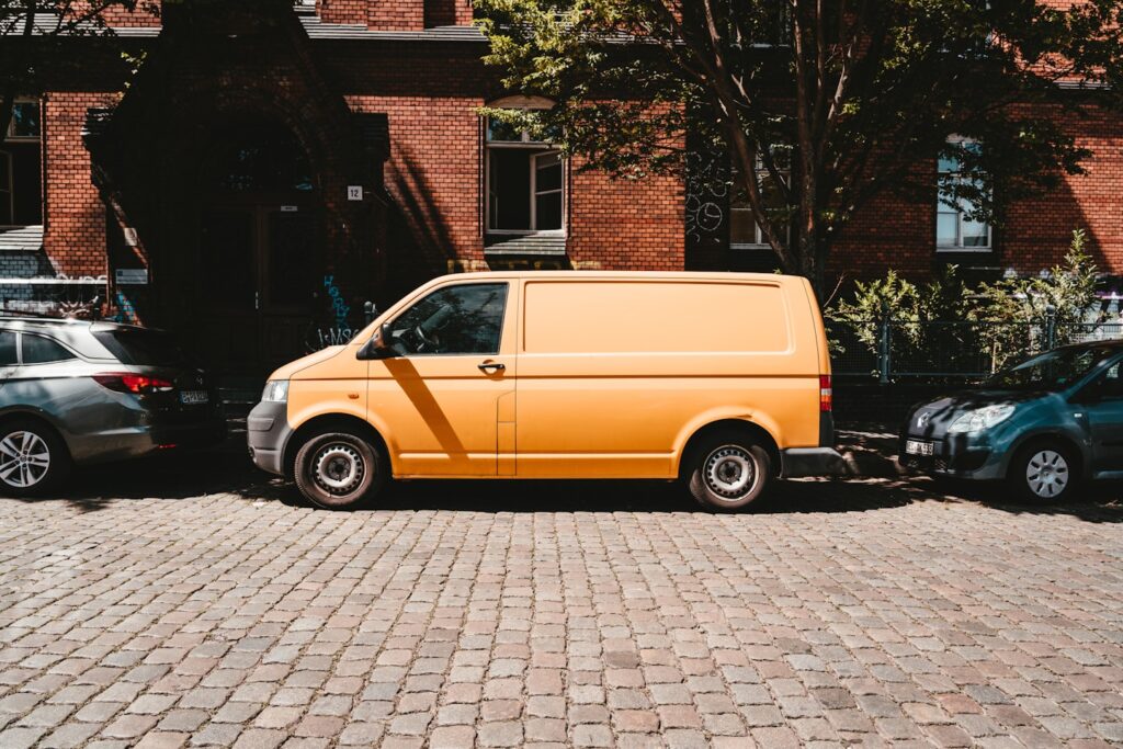 yellow van parked beside brown brick building